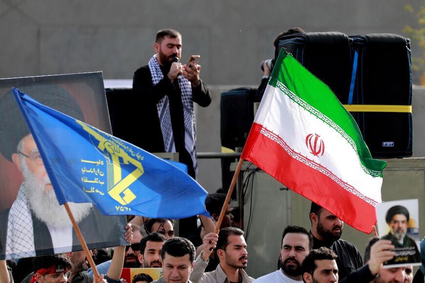 People wave flags of Iran and of its Islamic Revolutionary Guards Corps (IRGC) during a demonstration in solidarity with Iran in  Baghdad