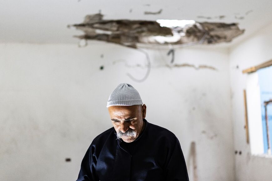 A member of the Druze community assesses the damage in a building that was hit overnight by a rocket fired from Lebanon, in the city of Shefa-Amr, or Shefar'am, east of Haifa in northern Israel