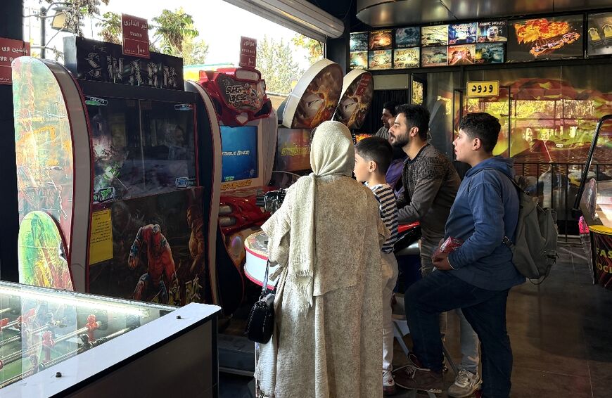 Iranians play games at an arcade in the capital. While some are trying to return to normal life under the ceasefire, others can't afford leisure activities