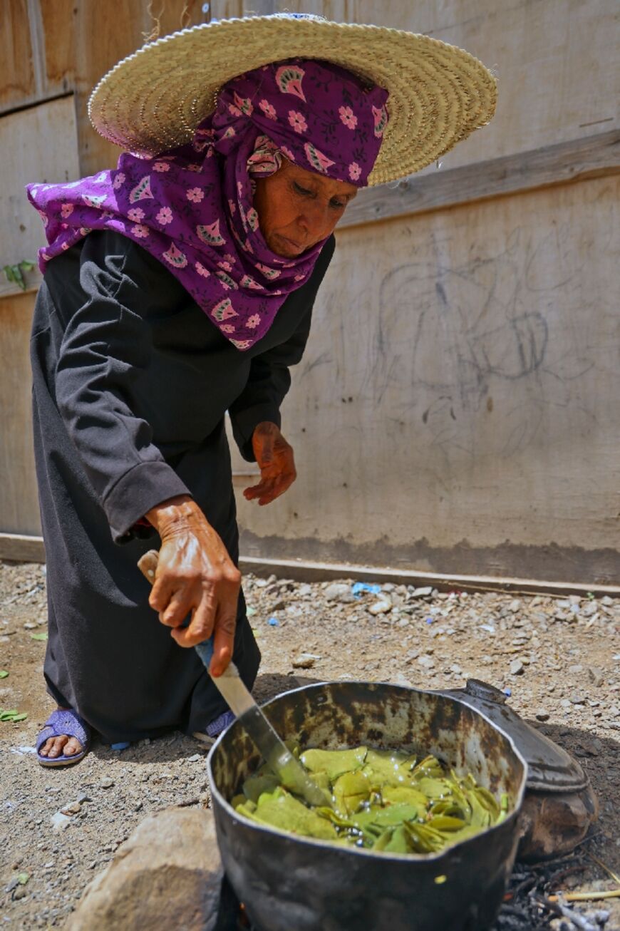 Saeedah Mohammed boils tree leaves for food