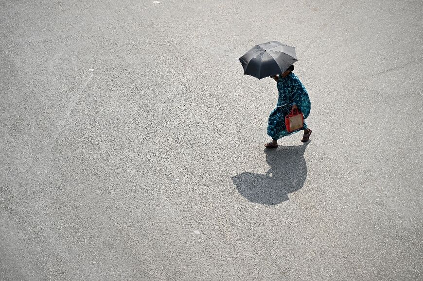 A pedestrian carries an umbrella on a hot day in Chennai