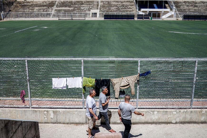 A dozen men from Gaza live in a former changing room under the bleachers of the stadium