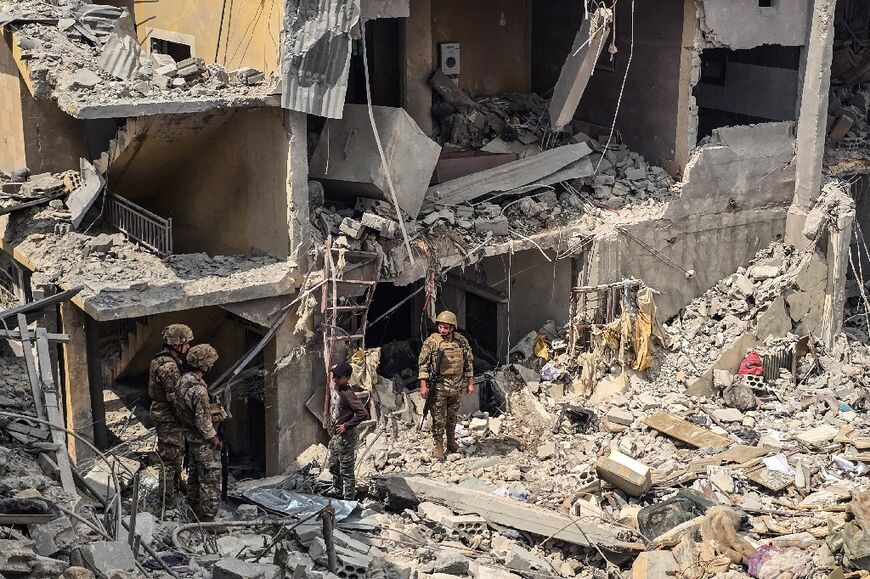 Lebanese soldiers stand amid the rubble of a residential building hit the previous day by an Israeli strike near the southern town of Burj al-Shamali, on the outskirts of Tyre, on May 27