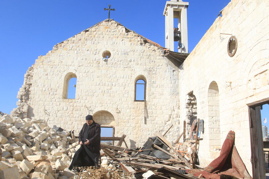 A worshipper walks inside the badly damaged St. George's Church, following a Christmass mass in the southern Lebanese village of Yaroun near the border with Israel on December 25, 2025. (Photo by Mahmoud ZAYYAT / AFP via Getty Images)