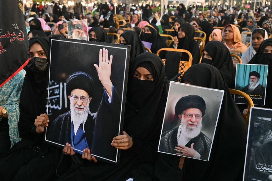 Activists carry portraits of Iran’s slain supreme leader Ayatollah Ali Khamenei, as they pay tribute at Minar-e-Pakistan in Lahore on June 13, 2026, during the Shaheed-e-Ummat conference.