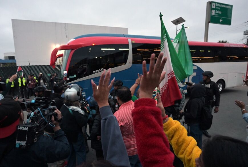 Football fans cheering Iran's team were kept at a distance as their bus drove by under Mexican police escort