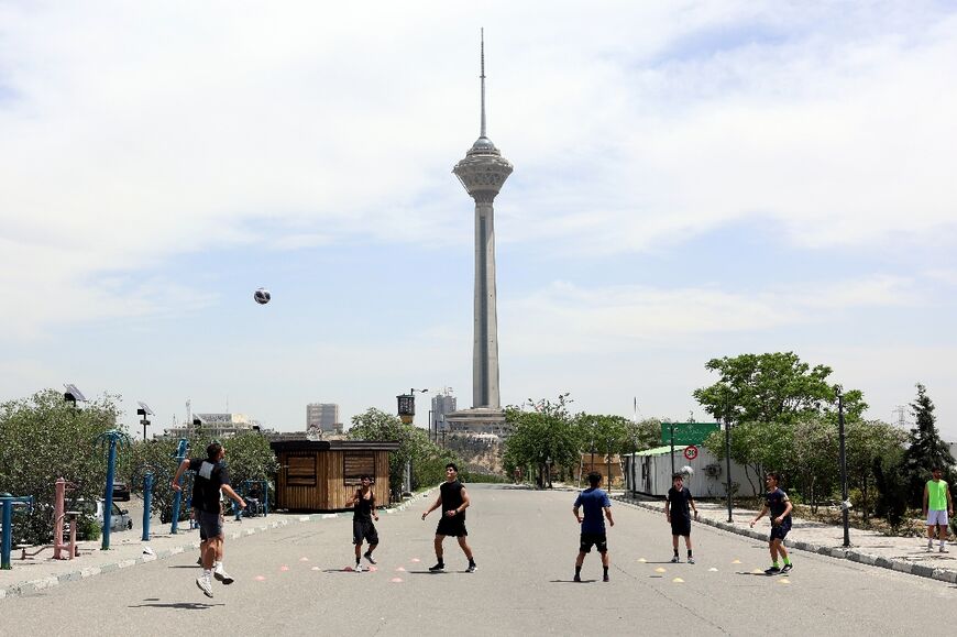 Young people play football near Milad Tower in Tehran last month