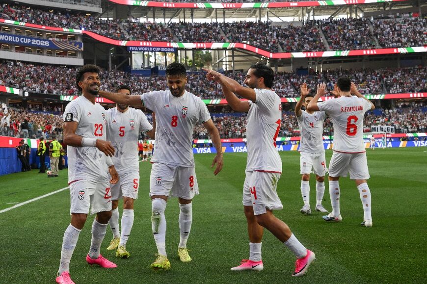 Iran's defender Ramin Rezaeian celebrates with teammates after scoring his team's first goal during the 2026 World Cup match against New Zealand 