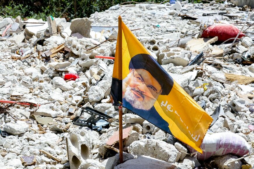 On a small street, a Hezbollah flag and a portrait of Nasrallah sat on a pile of rubble where an Israeli strike last month killed 14 people, nearly all from the same family, including three women and four children