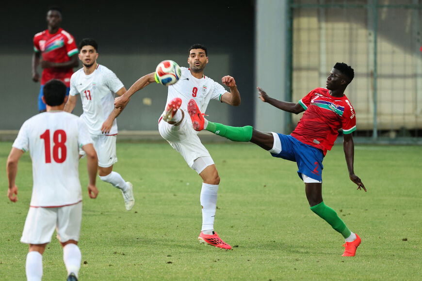 Iran's #9 Mehdi Taremi (C) fights for the ball with Gambia's #2 Mahmudu Bajo (R) during an international friendly football match between Iran and Gambia, in Antalya, southern Turkey, May 29, 2026, as part of Iran's preparation for the upcoming football World Cup. (Photo by Oner San/AFP via Getty Images)