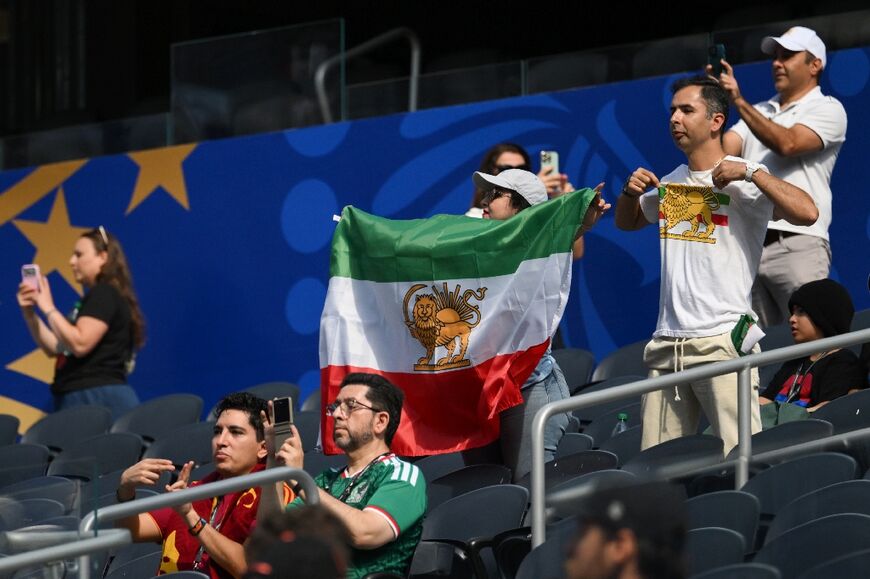 An Iranian fan shows a pre-revolutionary Iranian flag ahead of Iran's World Cup opener against New Zealand in Los Angeles