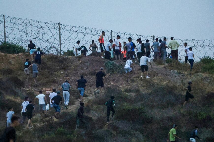 People seen gathering on hilltop on the Moroccan side of the border with Ceuta