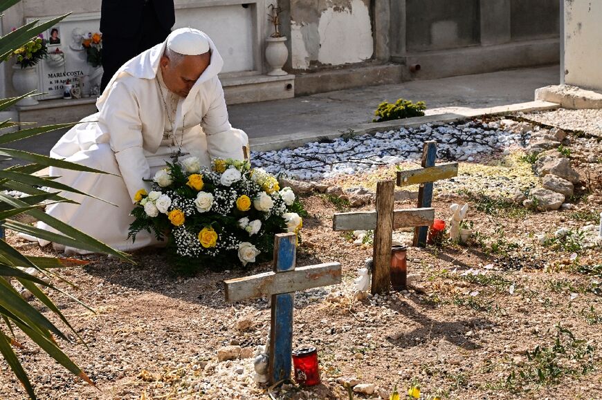 The pope lay a wreath of flowers on the unmarked graves of shipwreck victims at a cemetery on Lampedusa island