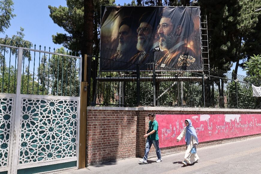 Images of Ali Khamenei stare down at Iranians alongside his son and predecessor