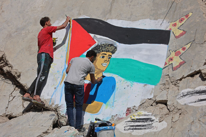 Palestinian artists paint a mural depicting football player Lamine Yamal waving a Palestinian flag during the Catalans' title parade, on the rubble of buildings destroyed during the war, at Shati (Beach) refugee camp in Gaza City on May 13, 2026. The high representative for Gaza in US President Donald Trump's Board of Peace on May 13 said the fragile ceasefire in the Palestinian territory was holding despite daily violations. (Photo by Omar AL-QATTAA / AFP via Getty Images)