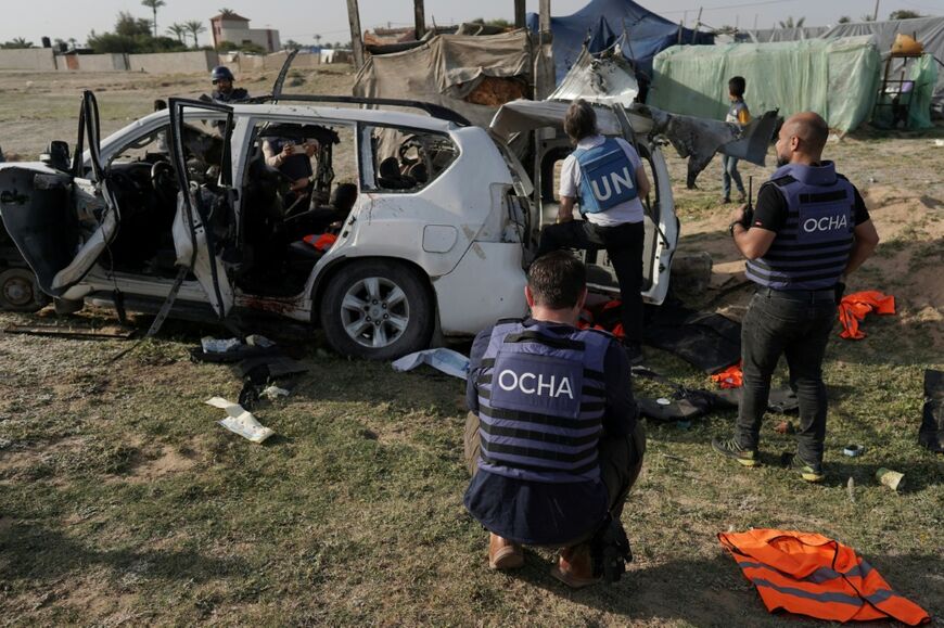 United Nations staff inspect the wreckage of a car used by the aid group World Central Kitchen after it was hit by an Israeli strike in Deir al-Balah in the central Gaza Strip in April 2024