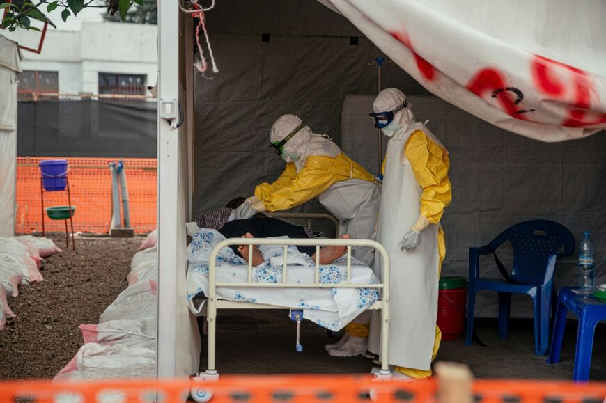 Doctors Without Borders (MSF) physicians move through the isolated red zone to monitor patients at an Ebola Treatment Center in Munigi, Congo