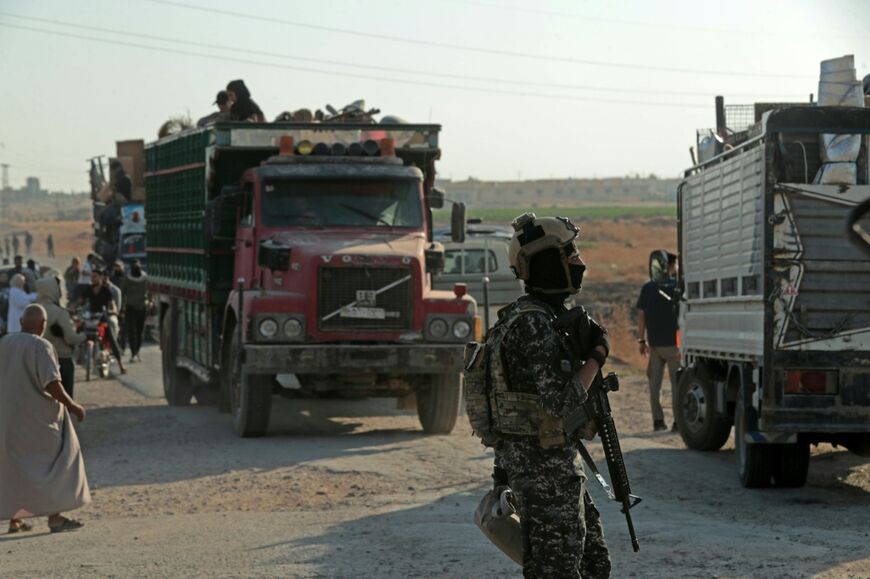A security officer stands guard as Syrian Kurds head from Hasakeh to Ras al-Ain