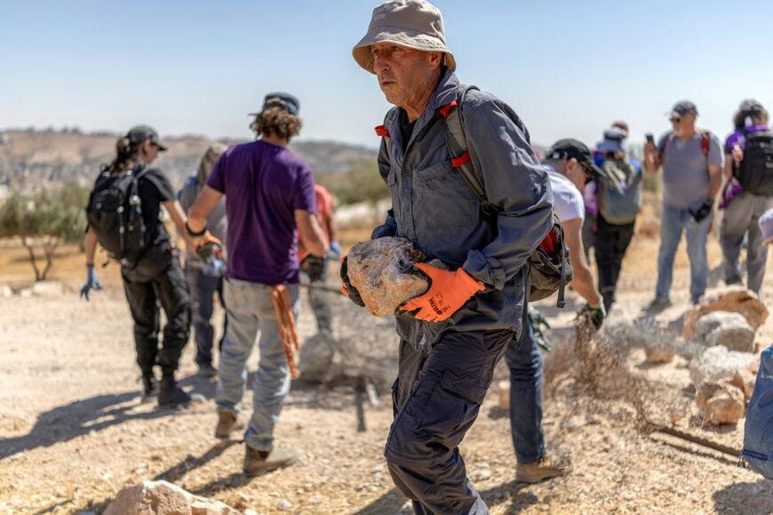 Israeli left-wing activists remove obstacles as they attempt to reopen a road that was blocked by Israeli settlers in the occupied West Bank Palestinian village of Jannatahon the outskirts of Bethlehem on August 25, 2026
