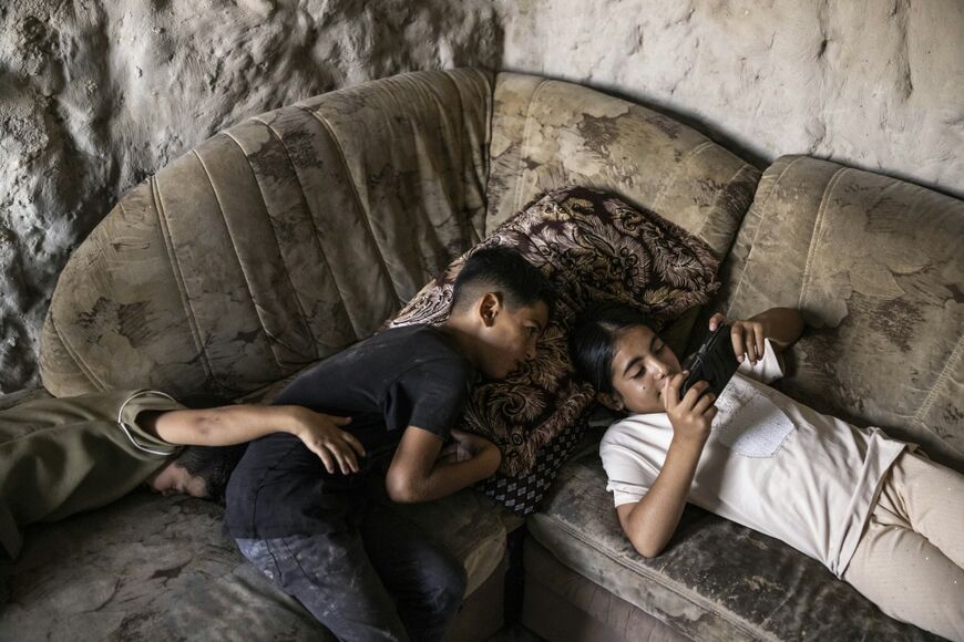 In the occupied West Bank's arid region of Masafer Yatta, Emar made a smooth concrete floor on two caves' rough limestone ground before applying a white limewash on the brittle stone walls