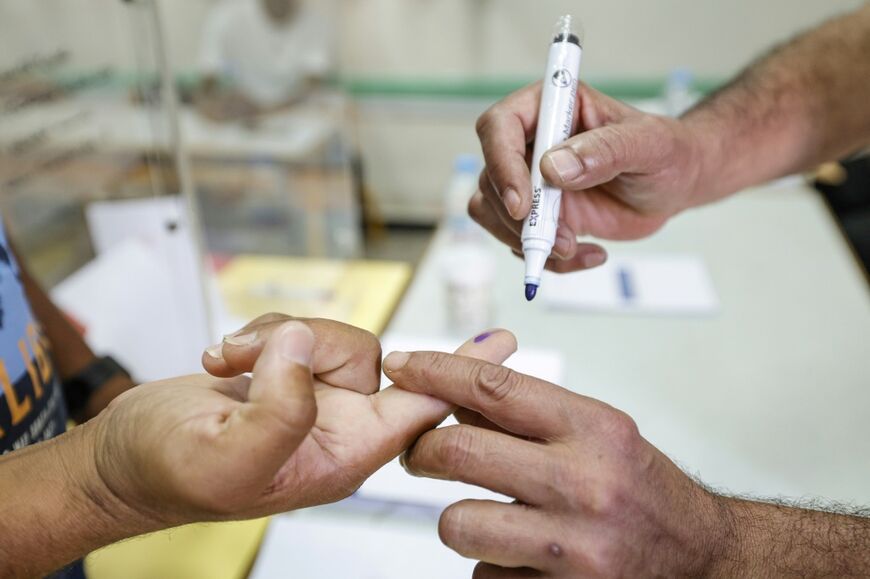 A man has his finger marked after casting his ballot at a polling station inside a school in Rabat