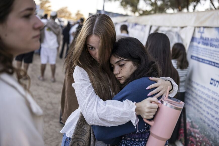 Young women hug at the memorial to the victims of the 2023 Hamas attacks at the Nova festival site in Reim, southern Israel