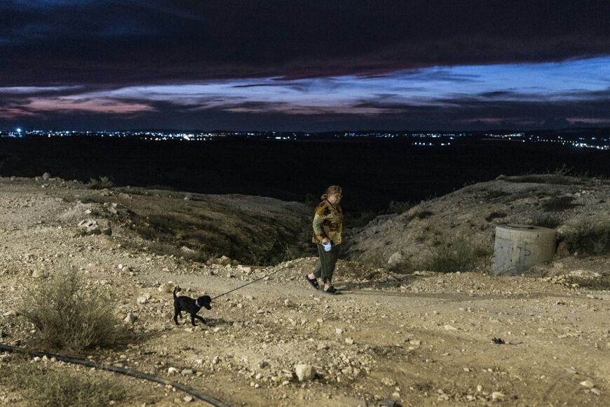 A woman walks her dog on the outskirts of Arad on October 1, 2026. Some secular residents acknowledge that day-to-day coexistence with the ultra-Orthodox population is generally peaceful.