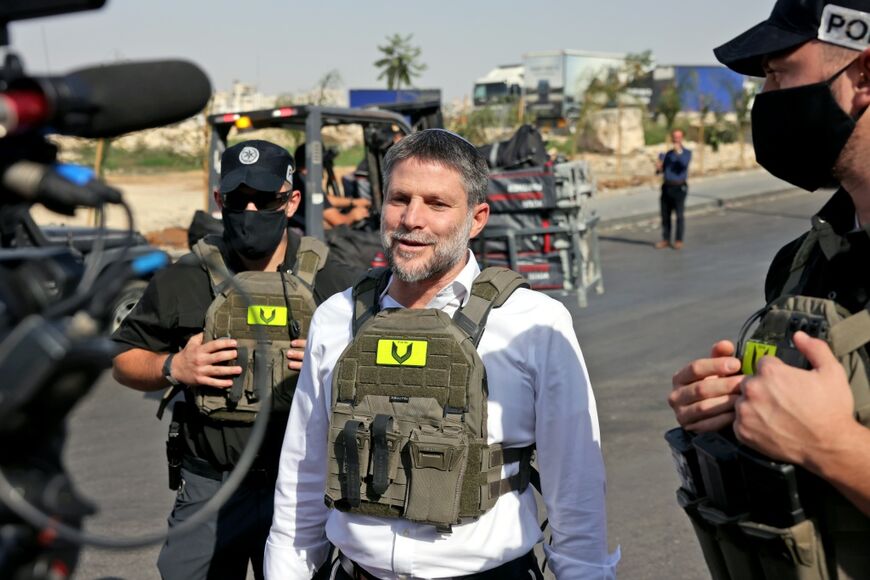 Far-right Israeli Finance Minister Bezalel Smotrich speaks to the press while visiting the scene of an attack near Hebron in the Israeli-occupied West Bank