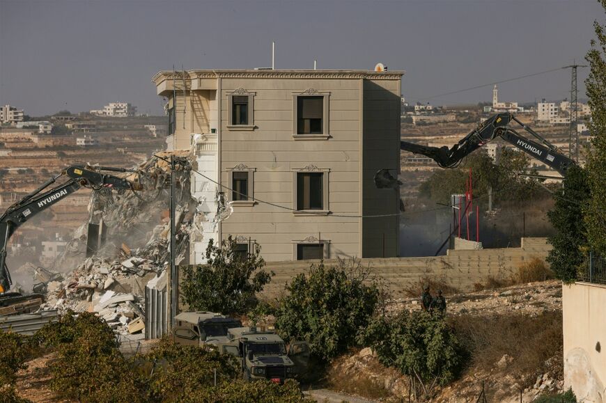 Israeli bulldozers demolish a Palestinian building in Hebron, citing a lack of construction permits