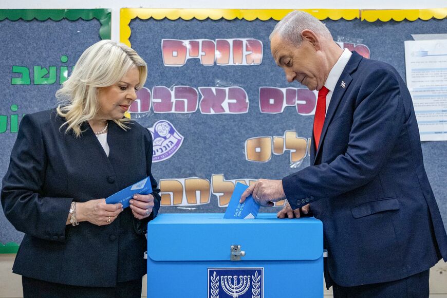 Israel's Prime Minister Benjamin Netanyahu (R) casts his ballot, next to his wife Sara, at a polling station in Jerusalem on October 27, 2026, on the day of Israel's legislative election.