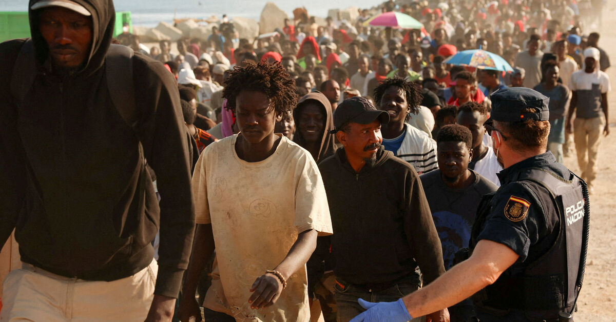 FILE PHOTO: Migrants are escorted from a makeshift beach camp to official shelters across the city after authorities cleared the site, following a mass crossing from Morocco, in Spain's North African enclave of Ceuta, August 20, 2026. REUTERS/Violeta Santos Moura/File Photo