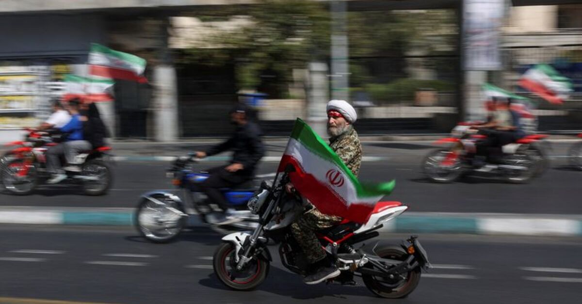 An Iranian cleric rides on a motorcycle as he participates in a march in Tehran