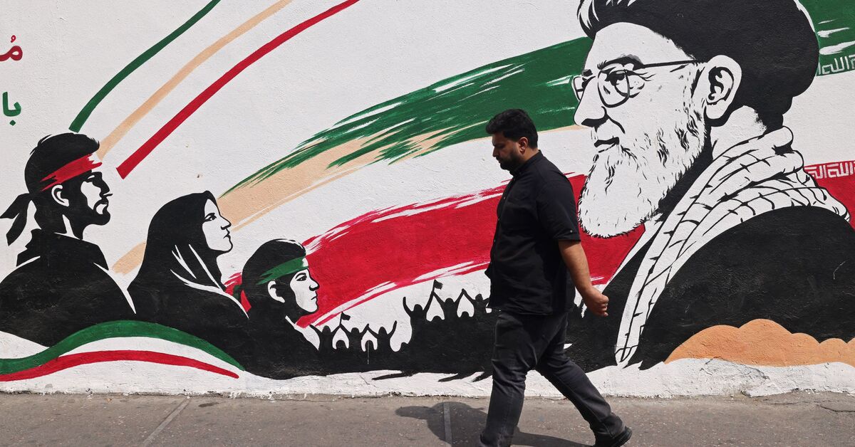 مردی در تاریخ ۳۱ آگوست ۲۰۲۶ از کنار دیوارنگاره‌ای از آیت‌الله علی خامنه‌ای، رهبر عالی‌قدرت ترورشده ایران، در خیابانی در مرکز شهر تهران عبور می‌کند.