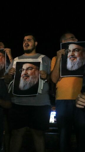 Demonstrators hold pictures of slain Hezbollah leader Hassan Nasrallah during a protest vigil in the southern Lebanese city of Sidon