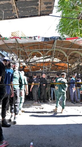 Syrian security forces and bystanders gather at the site of an explosion at a cafe in Damascus on Thursday